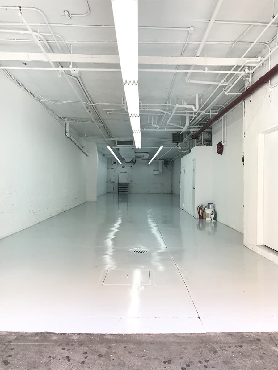 Long commercial space with a fresh glossy white floor coating